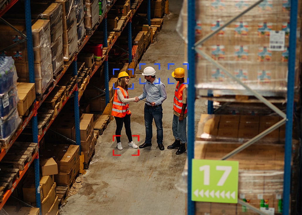 Industrial setting of 3 people with hard hats.